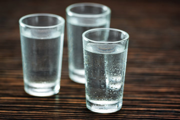 three shot glasses with vodka, selective  focus