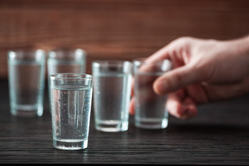 the hand takes a glass of  vodka,addiction to alcohol