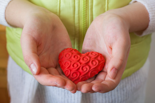 young girl holds in her hands handmade gift heart