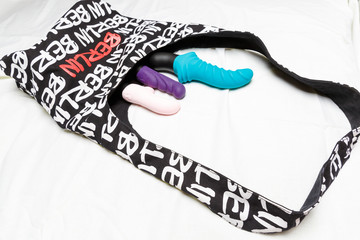 Many watches female vibrators with a bag on white background