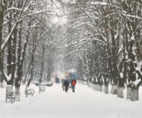 People walk on a snowy street. Blur picture