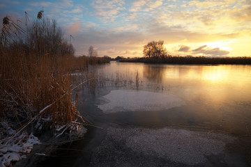 Winter landscape with sunset sky and frozen river. Daybreak