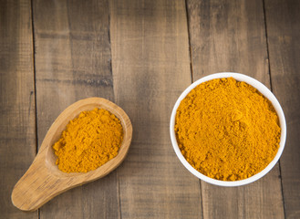 Turmeric in the bowl and wooden spoon (Curcuma longa)