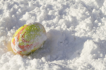 Yellow Rugby ball lying on the snow