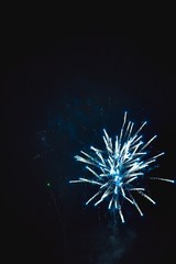 Shiny natural fireworks on dark black sky background with a litt