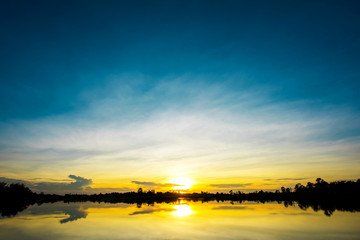Fototapeta na wymiar Beautiful sunset over lake with blue sky