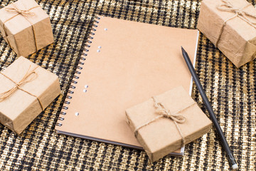 Christmas or New Year presents and notepad on golden background