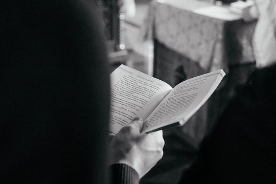 book in man's hand in russian church