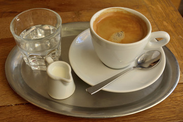 Coffee set with a cup of coffee, glass of water and milk. 
