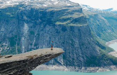 Man standing iconic cliff at Trolltunga Norway