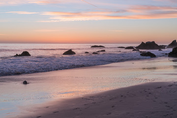 Fototapeta na wymiar Sunset reflected on the surf at E Matador Beach Malibu