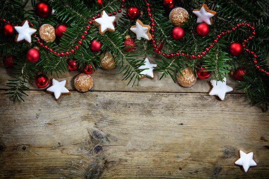 Fir Tree Branches With Red Christmas Balls And Cookies Ond Rustic Wood, Holiday Background