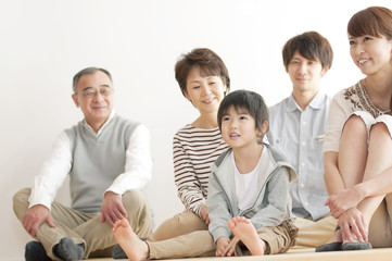 床に座り微笑む3世代家族