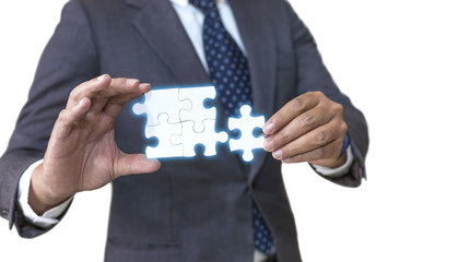 Business solutions, success and strategy concept. Businessman hand connecting jigsaw puzzle isolated on white