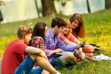 Fototapeta premium a group of students with laptop relaxing in the Park on a Sunny day