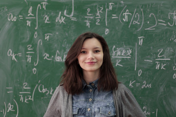 Portrait of beautiful girl student in front of maths chalkboard