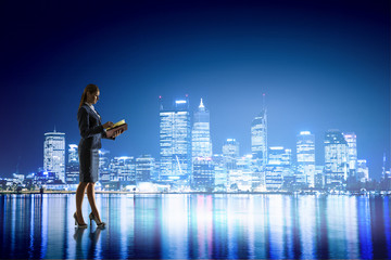 Fototapeta na wymiar Rear view of businesswoman looking at night city . Mixed media