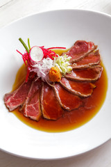 japanese cuisine beef tataki poured with soy sauce
