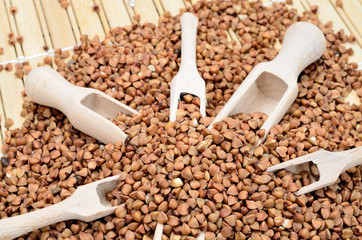 brown buckwheat with scoop on table