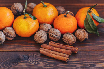 fresh juicy ripe tangerines with leaves walnuts and cinnamon