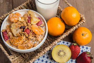 granola with ftuits salad on the wood background.