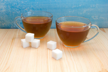 glass mug with tea and sugar cubes