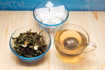 glass mug with tea , sugar bowl and glass Cup of green tea with Jasmine
