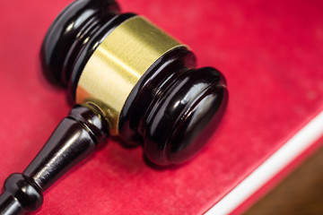 Gavel on red cover legal textbook