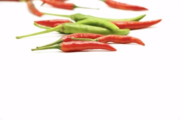 Green and red chilli on white background