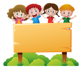 Four children standing behind wooden sign
