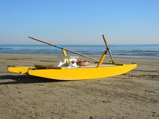 Obraz premium Yellow rescue rawboat on Italian beach. Adriatic sea. Emilia Romagna. Italy