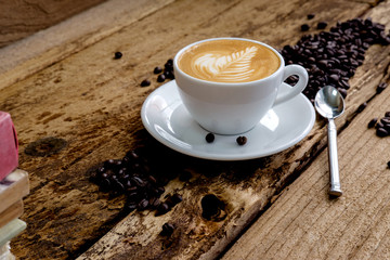 Cup of coffee and beans on a wooden table