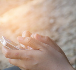 Hand of a woman playing a smart phone.