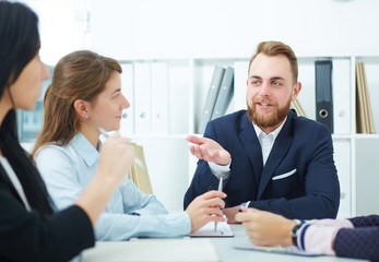 Image of business partners discussing documents and ideas at meeting.