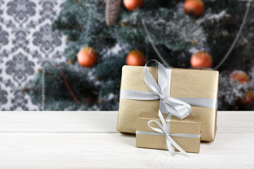 Christmas present on decorated tree background, holiday concept