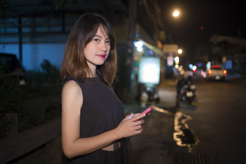 asian woman are using the smart phone on the road