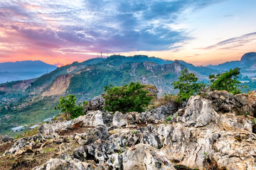 Rock formations on top of a hill, taken at sunrise. Showing bright colorful sky and beautiful clouds. Taken in a place called Stone Garden, West Java, Indonesia