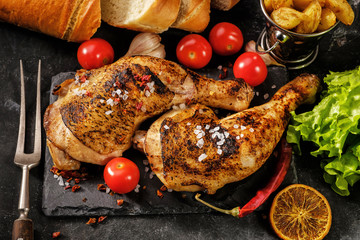 Two grilled chicken legs roasted with oranges
