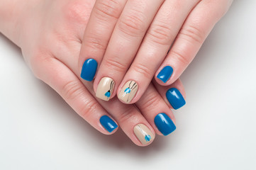 Obraz na płótnie Canvas Blue and beige manicure with delicate flowers on the square short nails