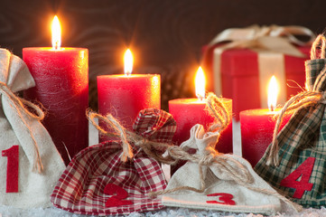 Rote Adventskerzen im Schnee