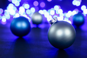Blue christmas ball and blured purple lights at the background