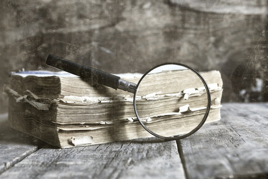 old scratched effect on photo magnifying glass and old book