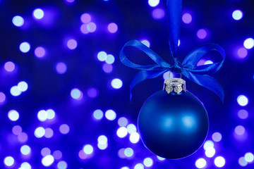 Naklejka na ściany i meble Blue christmas ball and blured purple lights at the background