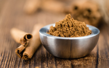 Portion of Cinnamon Powder on wooden background (selective focus