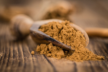 Portion of Cinnamon Powder on wooden background (selective focus