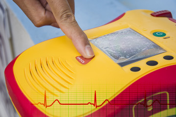 Automated External Defibrillator show finger push button shock - obrazy, fototapety, plakaty