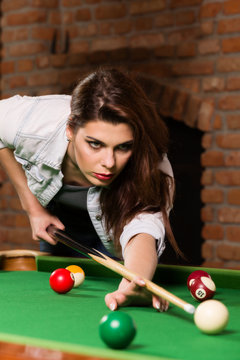 Woman playing billiards