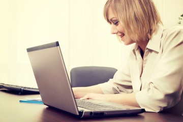 Blonde businesswoman working on computer at the office