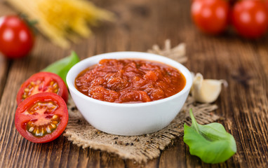 Wooden table with Tomato Sauce (selective focus)
