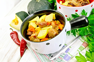 Roast meat and vegetables in white pots on board